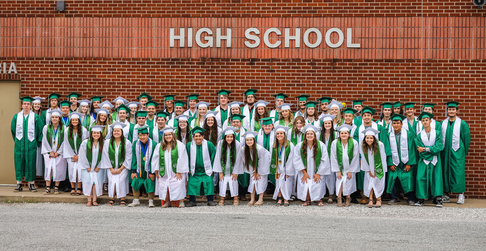 Graduates in their green or white caps and gowns.