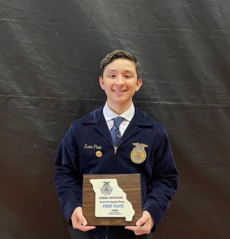 High school boy in FFA jacket with plaque.