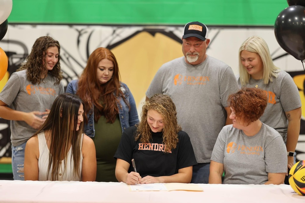 Hailey surrounded by family and coaches while signing.